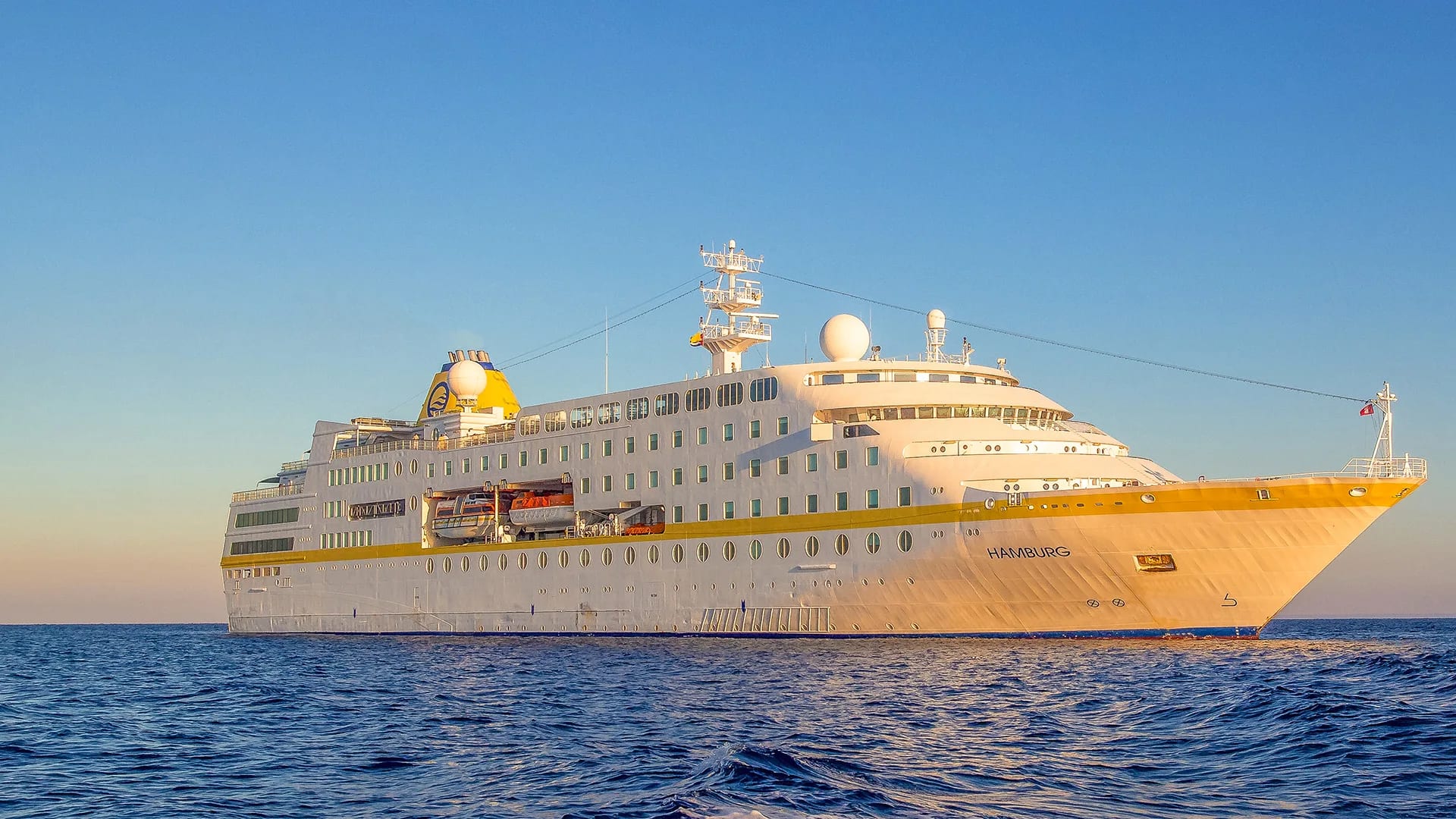 Hochsee-Kreuzfahrtschiff im warmen Abendlicht auf offener See